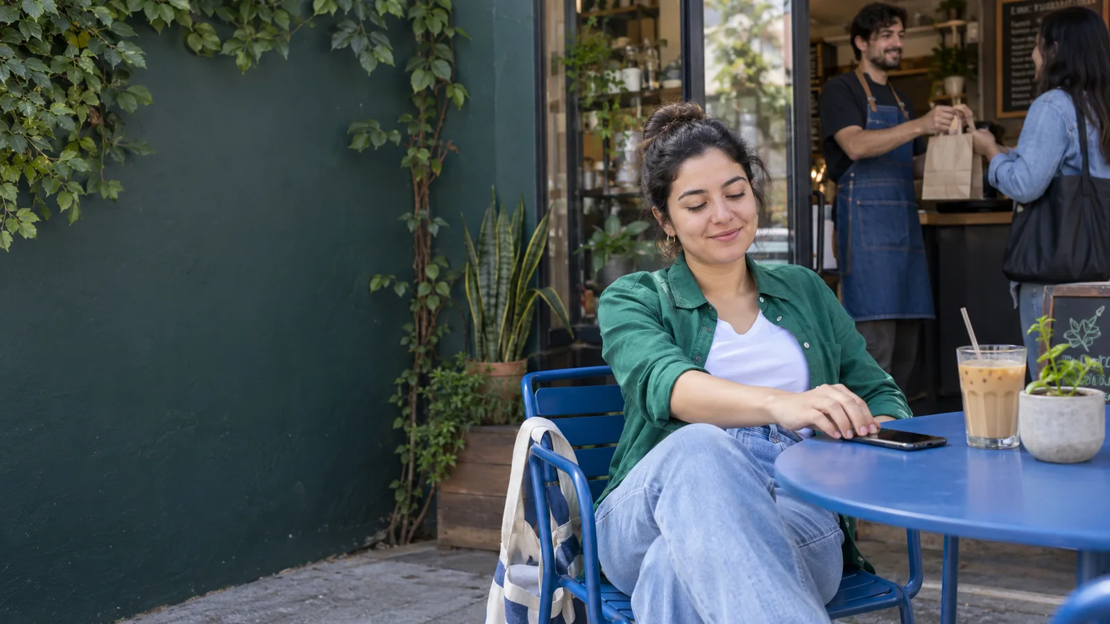 A café owner enjoys a quiet moment outside the café.