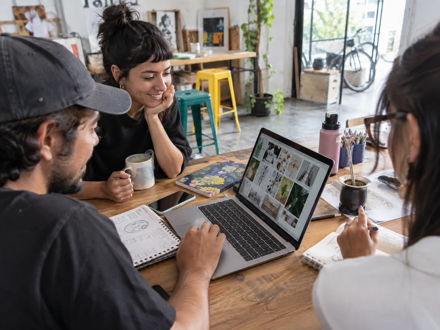 A small design team reviews a customer project around a table.