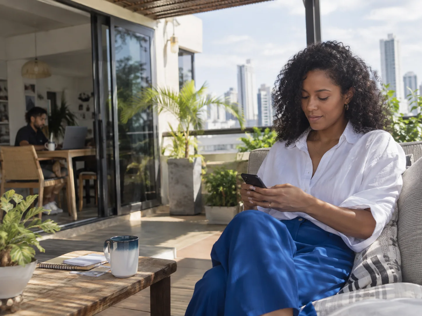 A creative agency owner reviews a message from a terrace.