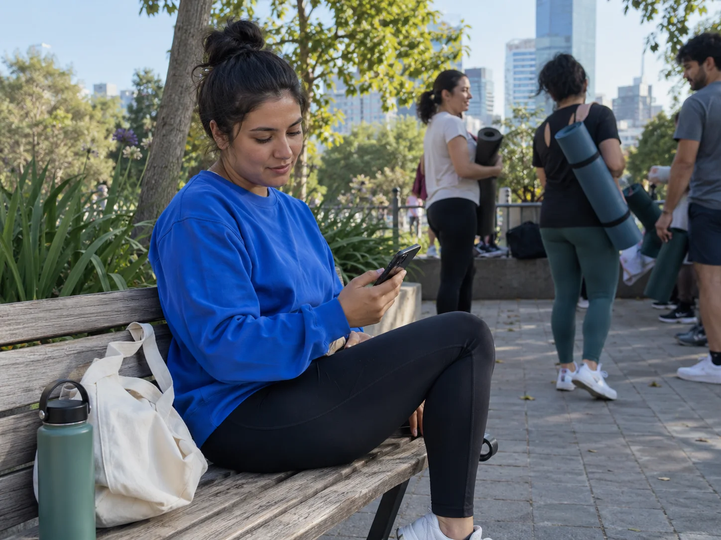 A yoga instructor manages class bookings after an outdoor session.